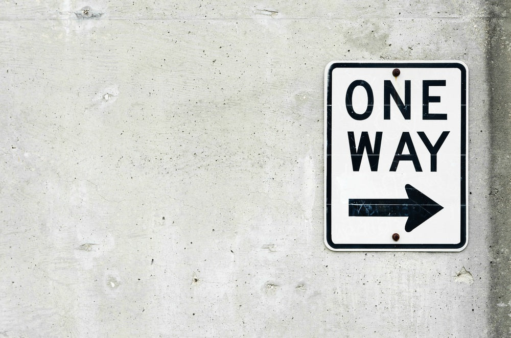 One Way Street Sign on a Concrete Wall
