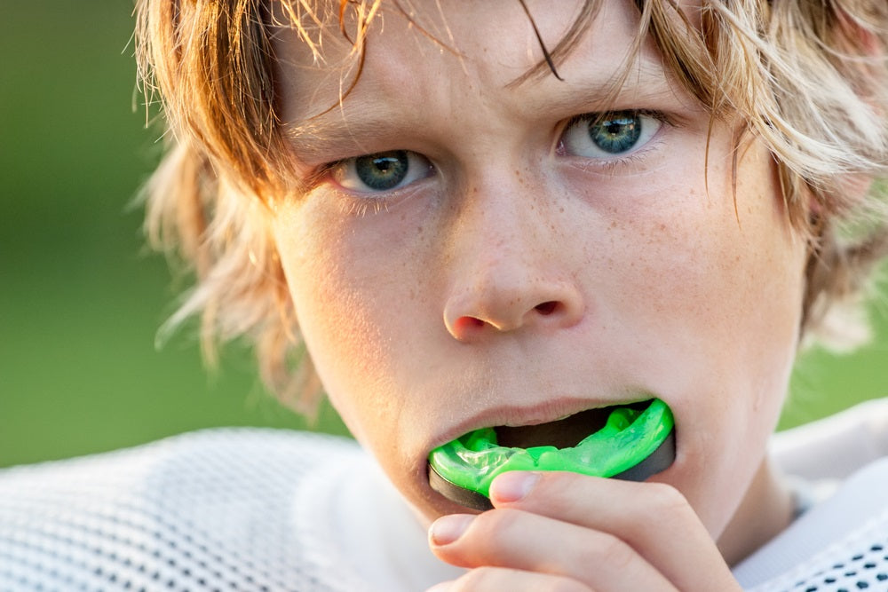 Young Football Player Putting in His Mouth Guard