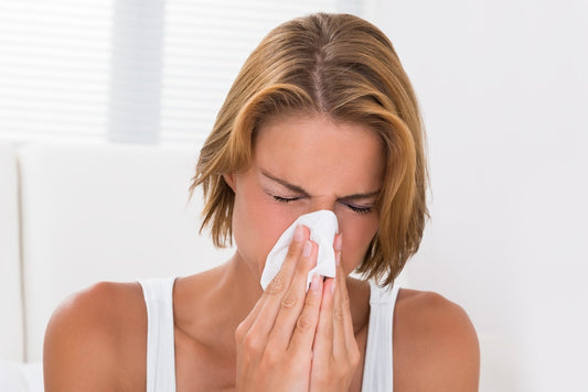 Woman With a Headache and Blowing Her Nose