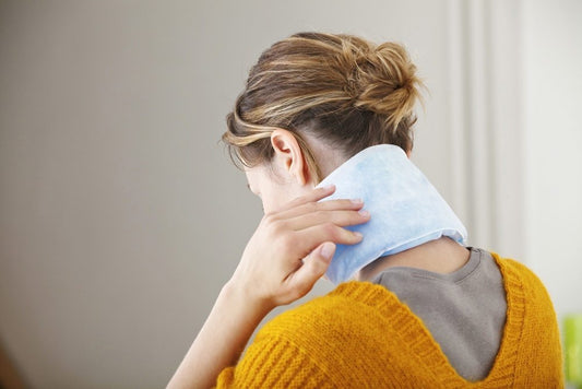 Woman relieving tension headache with heating pad
